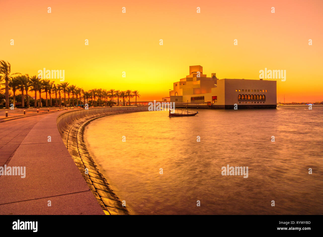 Der Gehweg mit Palmen entlang der Bucht von Doha. Museum und Dhow bei Sonnenuntergang. Malerische Stadt Stadtbild. Qatari Kapital in Naher Osten, Arabische Halbinsel Stockfoto