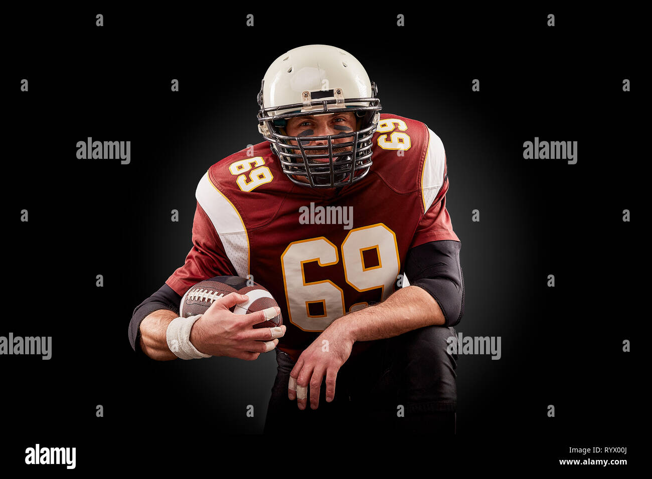 Portrait von American Football Spieler mit einem Ball mit beiden Händen Stockfoto