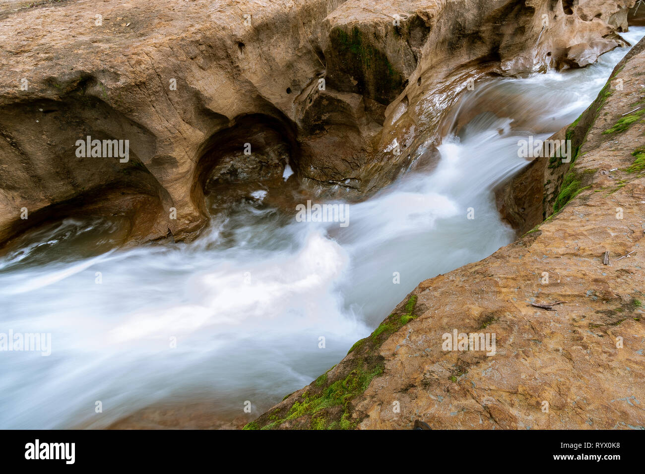 Das Wasser fließt durch einen kleinen Sandstein Slot Canyon in Südkalifornien. Starke Strömung von Wasser nach den letzten Frühling Regenschauer. Stockfoto