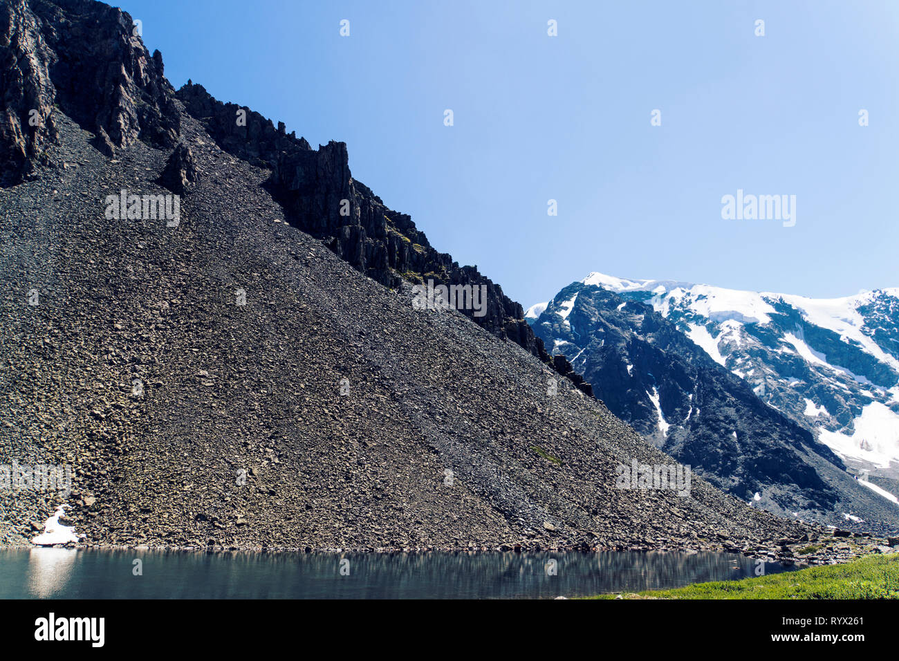 Halden. Kurumnik ist ein Haufen Fragmente von Felsen. Die Streuung der große Steine in den Altai Bergen im Hintergrund der schneebedeckten Gipfeln. Stockfoto