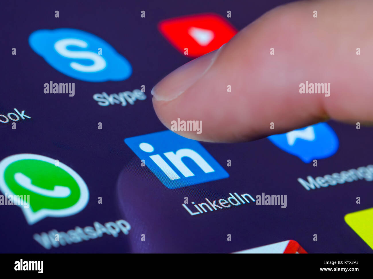 Finger drücken der Linkedin App Symbol auf einem Tablet-PC oder Handy Touchscreen. LinkedIn Verknüpfung. Stockfoto