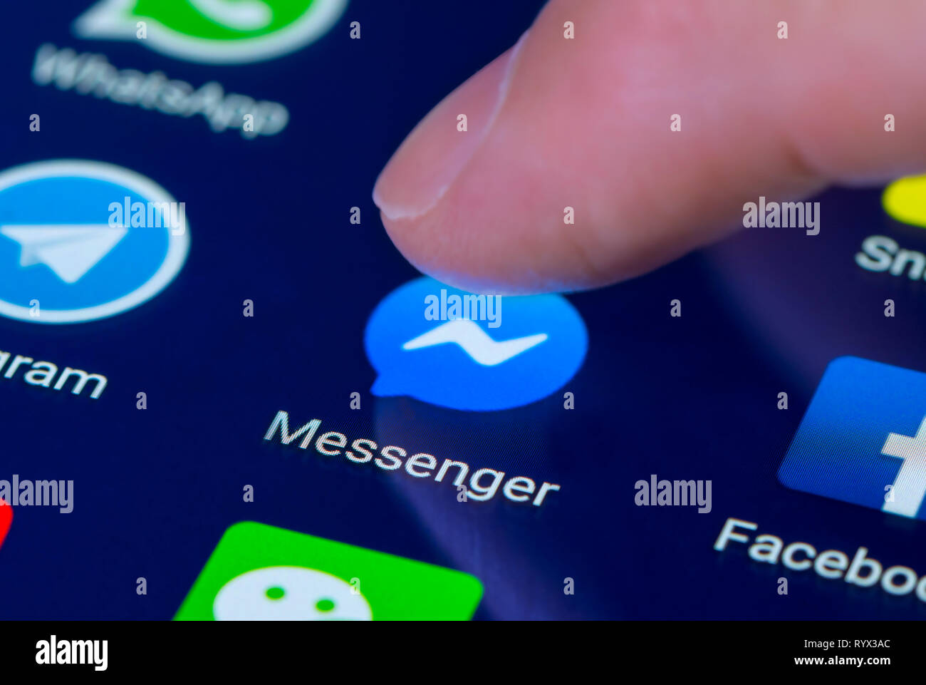 Finger, mit der Facebook Messenger App Symbol auf einem Tablet-PC oder Handy Touchscreen. Facebook Messenger Verknüpfung. Stockfoto