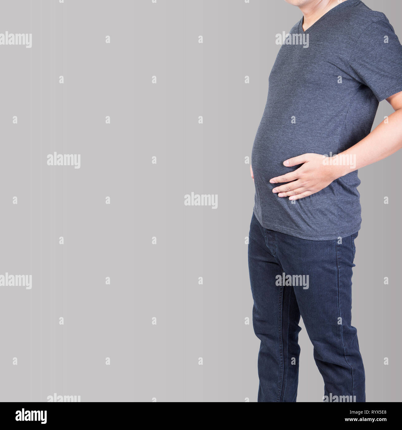 Fetter Mann mit Bauch Fett überschüssige Hand auf Bauch isoliert auf grauem Hintergrund Stockfoto