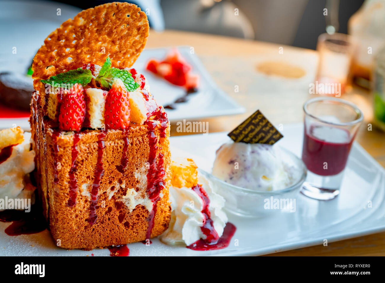 Honig toast Richtfest mit Erdbeeren, Sahne, Vanilleeis. Brot Toast auf weißem Teller auf unscharfen Hintergrund der Schokolade lava c Stockfoto