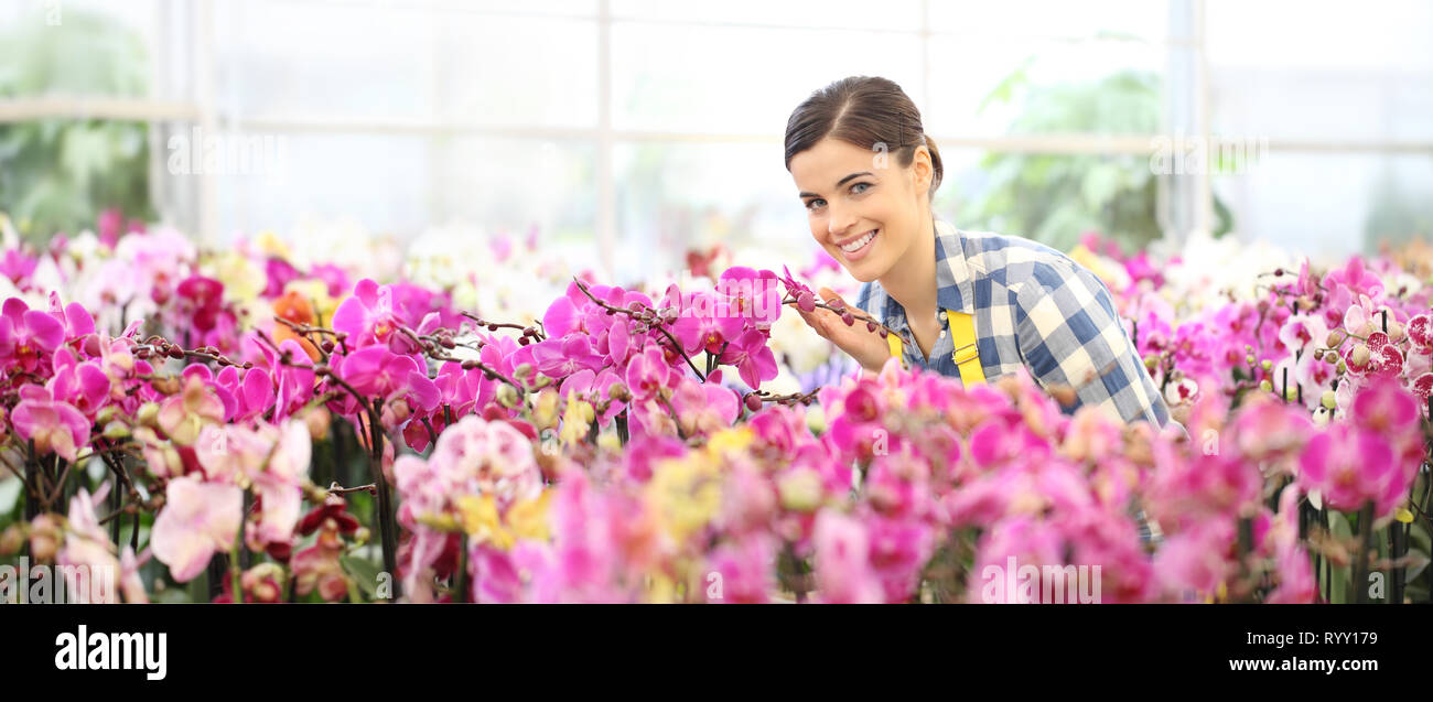 Feder Konzept, lächelnde Frau im Garten Orchideen Blumen Stockfoto