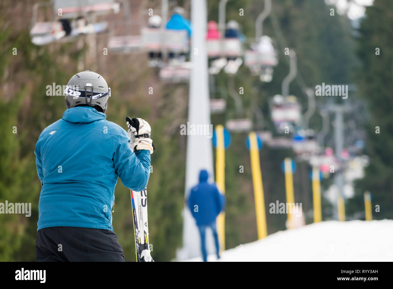 Szklarska Poreba, Polen - Februar 2019: Skifahrer trägt blaue Winterjacke ruht auf seine Skiausrüstung, Szrenica Berg, Riesengebirge Stockfoto