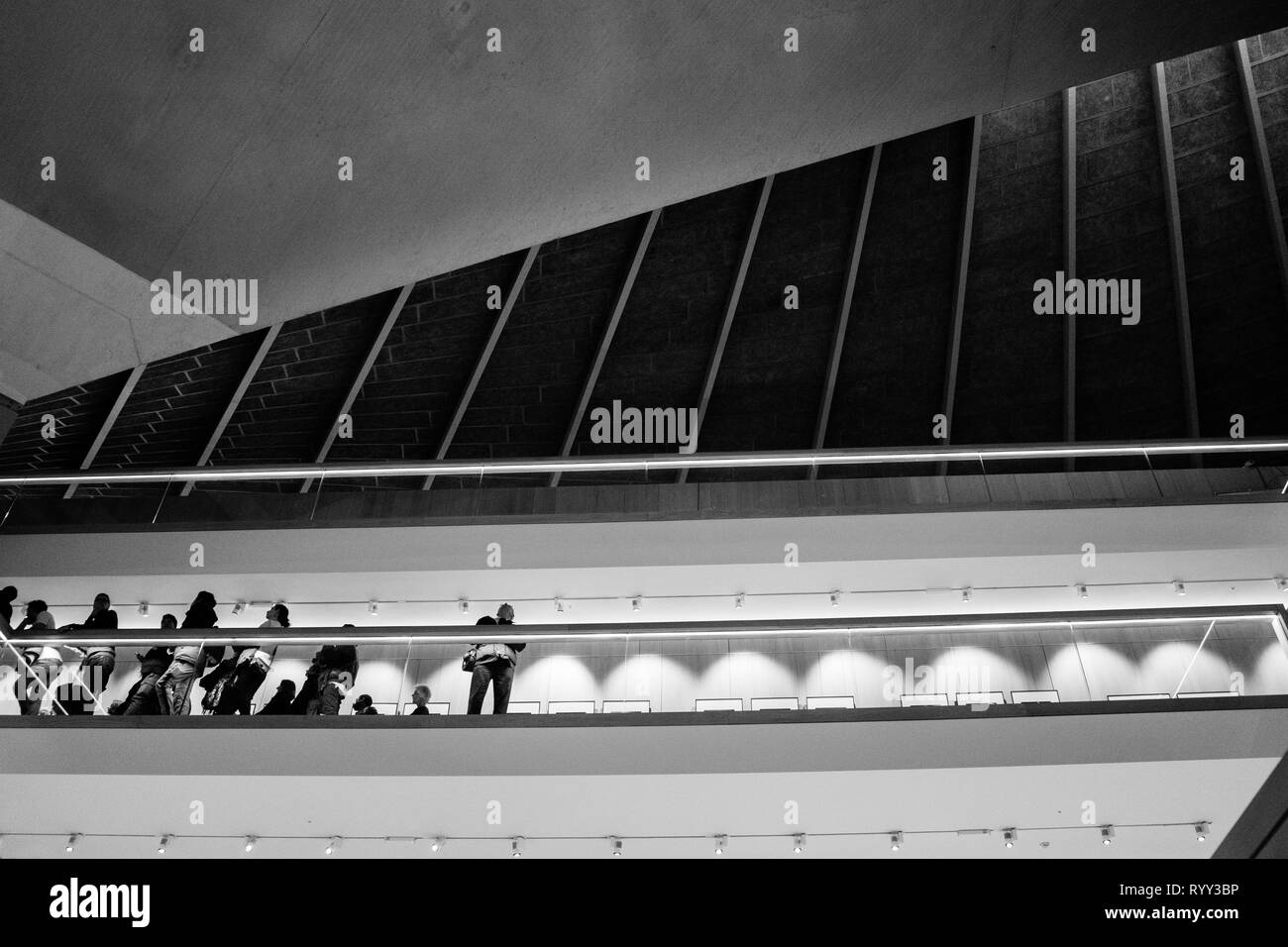 Leute zum Betrachten der Galerie unter dramatischen architektonischen Linien - Schwarz und Weiß - London, Großbritannien Stockfoto