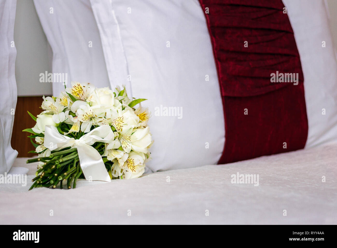 White Wedding Bouquet auf dem Bett - weisse Hochzeit Blumen - Auf dem Bett - romantisch-Bild Stockfoto