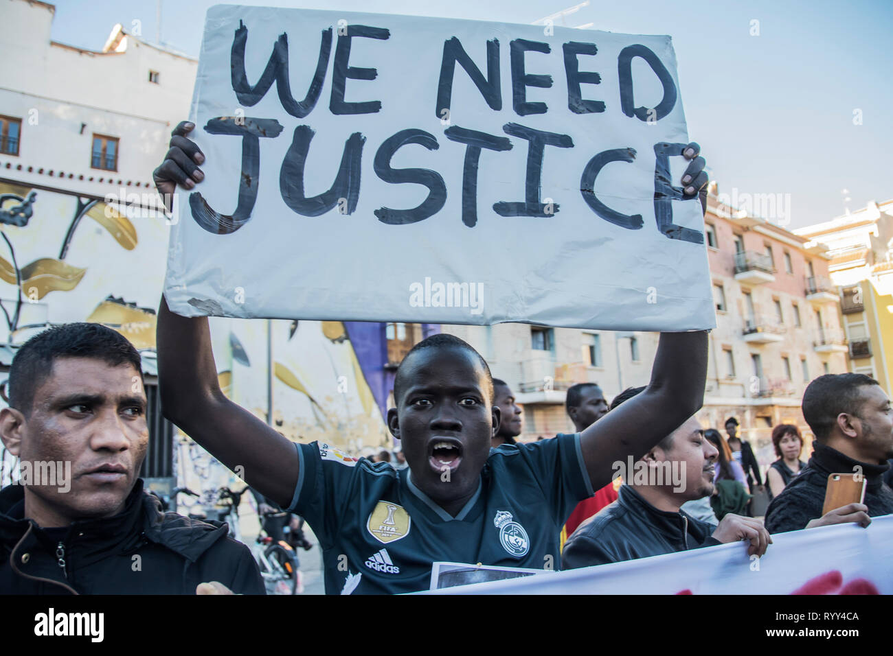 Ein Kerl mit einem Plakat ¨ wir Gerechtigkeit ¨ Nein mehr institutionelle Rassismus in Madrid, Spanien. März zu einem Jahr des Todes von senegalesischen Anbieter Mame Mbaye in der Calle del Oso in der Nachbarschaft von Lavapies. Vor einem Jahr gab es eine Zusammenstößen zwischen der Polizei und Immigranten nach Mmame Mbage, einem senegalesischen Straßenhändler, gestorben an einem Herzstillstand angeblich nach dem von der örtlichen Polizei gejagt werden gedenken müssen. März eines Jahres nach dem Tod des senegalesischen Anbieter Mmame Mbage in Lavapies Square Nelson Mandela zu gedenken. Vor einem Jahr gab es eine Auseinandersetzung zwischen der Polizei und Immigranten nach Mmame Mbage, gestorben an einem Herzstillstand Stockfoto