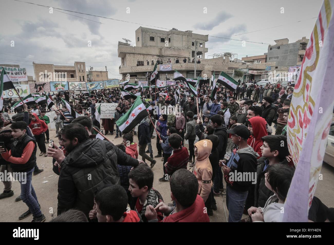 Syrer gesehen Holding opposition Flaggen während der Feier. Syrer in der Stadt Bensh, die liegt östlich von Idlib und gesteuert von der Opposition, feierte den achten Jahrestag des Aufstandes gegen die Herrschaft von Präsident Baschar al-Assad. Stockfoto