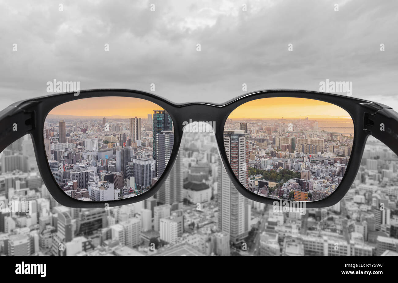 Durch die Brille mit Blick auf die Stadt bei Sonnenuntergang. Farbenblindheit Gläser, Smart glass technology Stockfoto