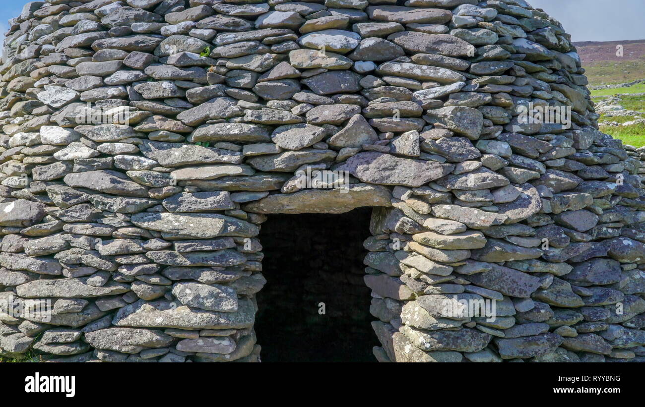 Ein big Beehive Hut in der Farm Hill in Irland mit der kleinen Tür öffnen, im Inneren der Hütte Stockfoto