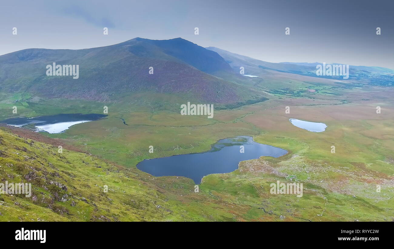 Der Blick auf die Berge und das kleine Seen, in denen gesehen werden kann, wenn auf der Oberseite der SkyRoad in Irland Stockfoto