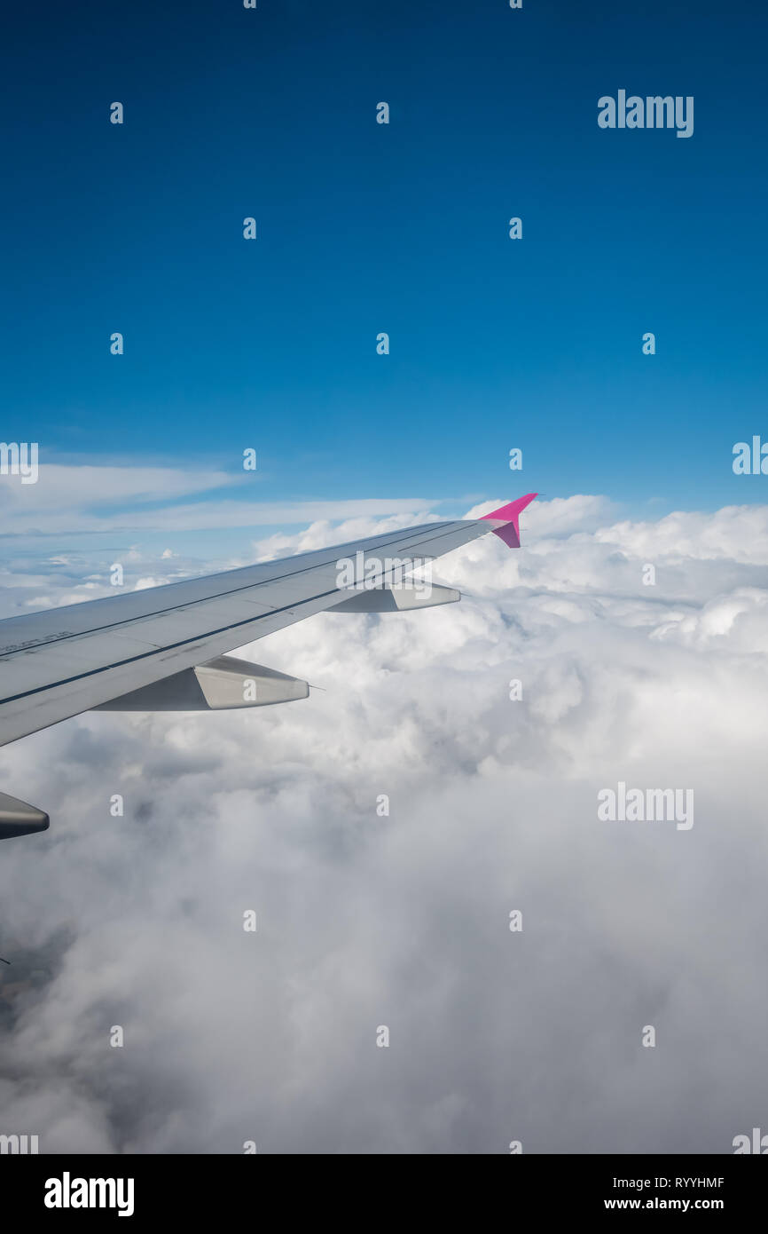 Luton, England - September 2018: Fenster mit Blick auf den Flügel eines Flugzeugs fliegen über den Wolken Stockfoto