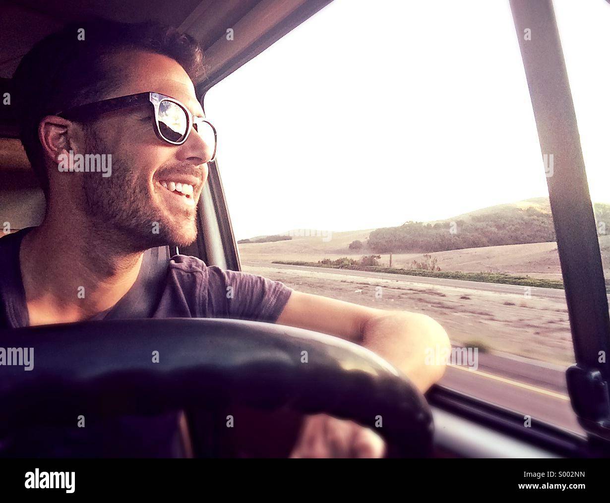 Junger Mann fährt VW Westfalia auf Highway 101 in Kalifornien, USA Stockfoto