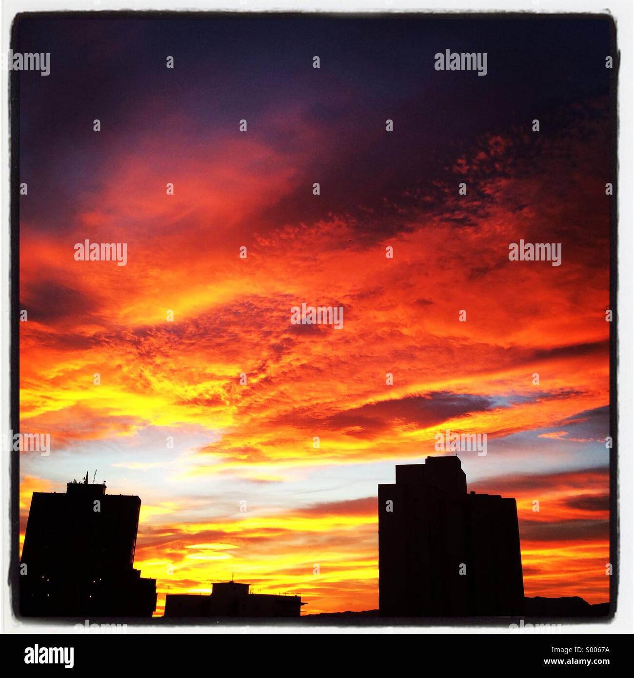 Dramatischer Himmel bei Sonnenuntergang mit Silhouette Gebäude Stockfoto