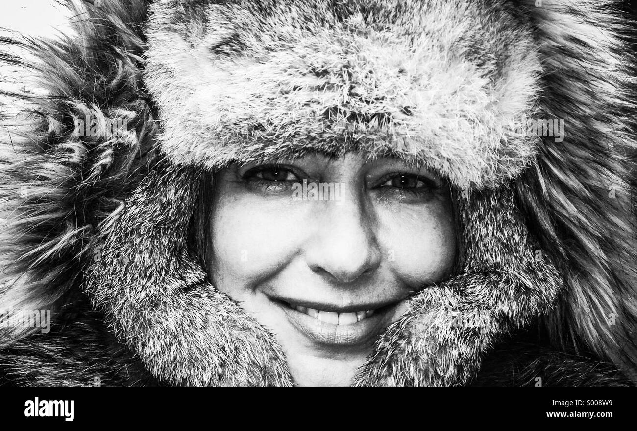In sub-Zero Wetter eine Frau lächelt, als sie versucht, um warm zu bleiben. Stockfoto