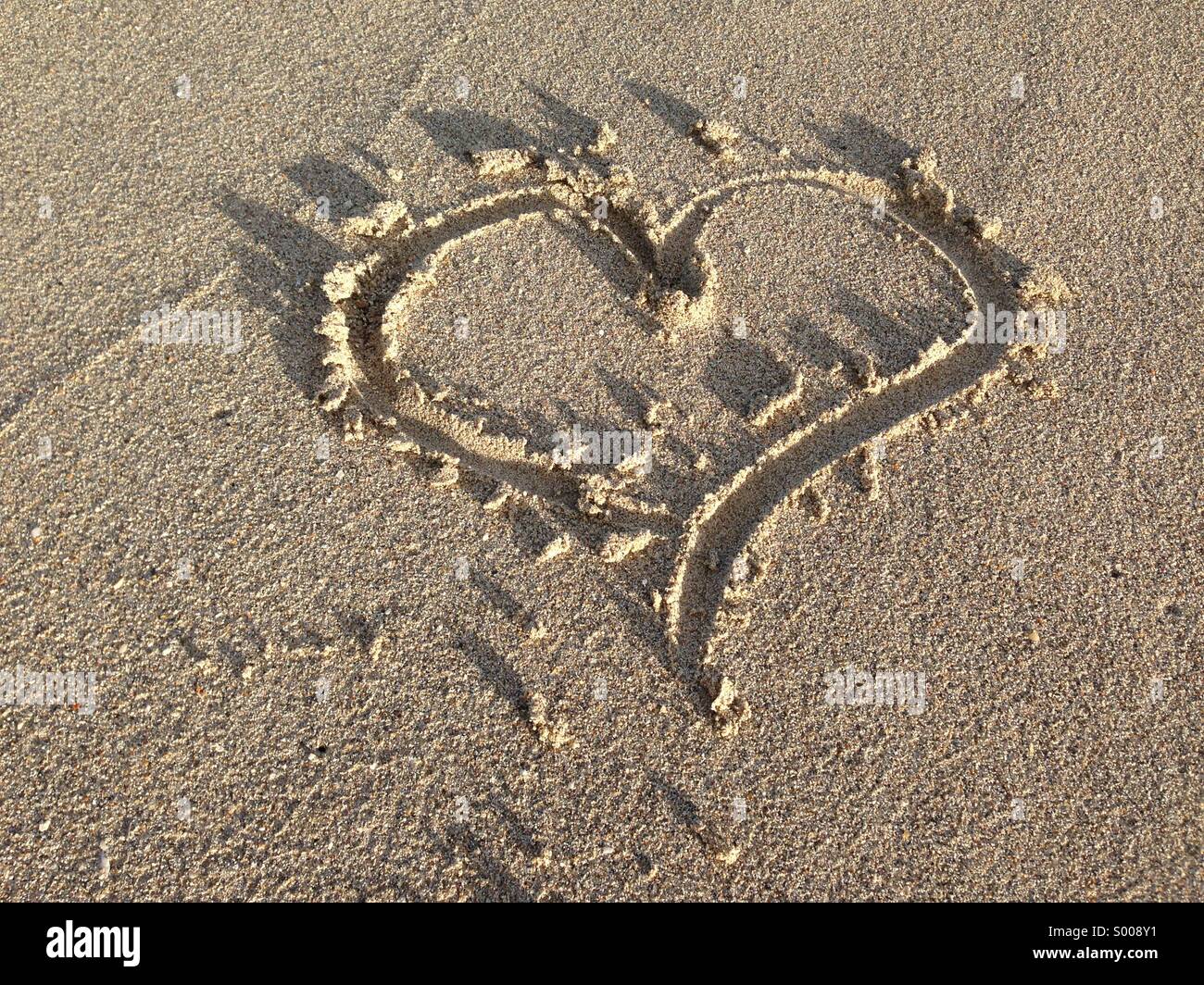 Ein Herz in den Sand gezeichnet. Stockfoto