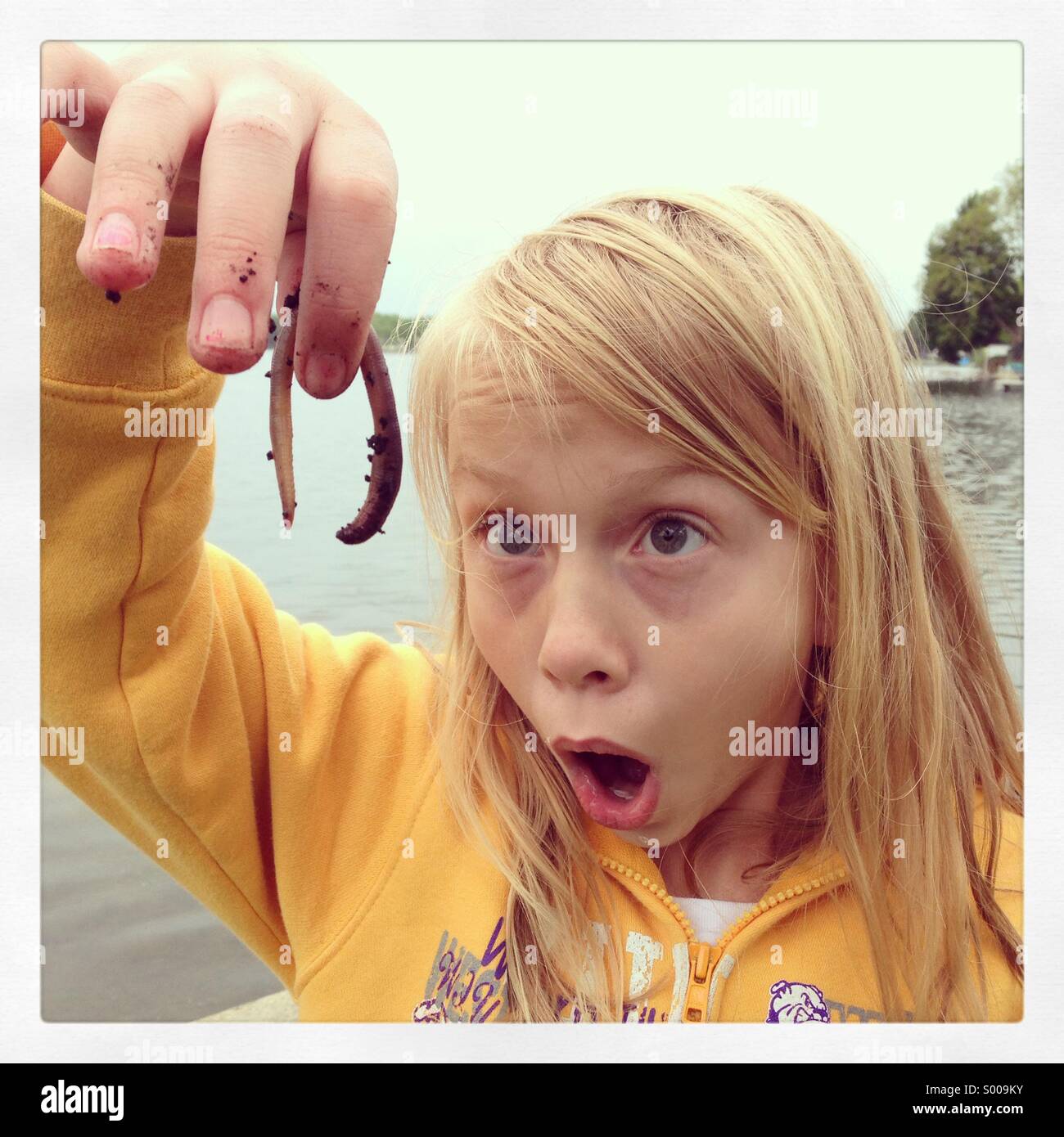 Ein Mädchen Augen leuchten beim Betrachten einer squirmy crawly getragen. Stockfoto