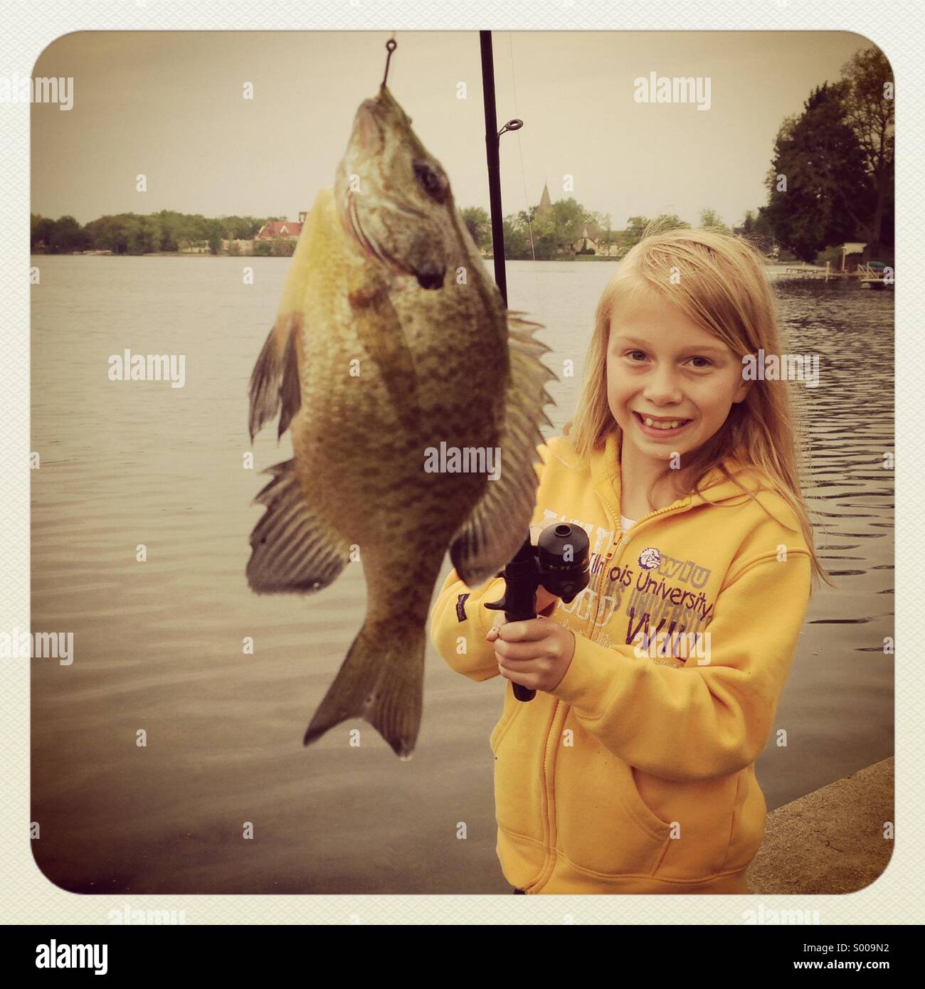 Ein kleines Mädchen Rollen in einen kleinen Fisch. Stockfoto