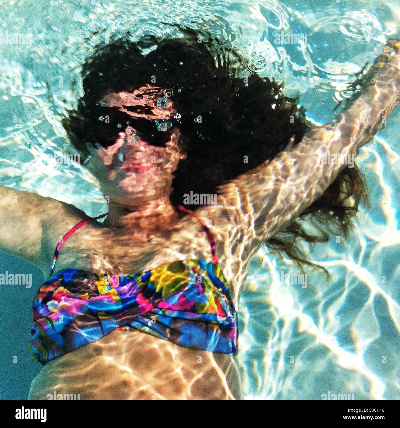 Mädchen unter Wasser in bunten Badeanzug Stockfoto