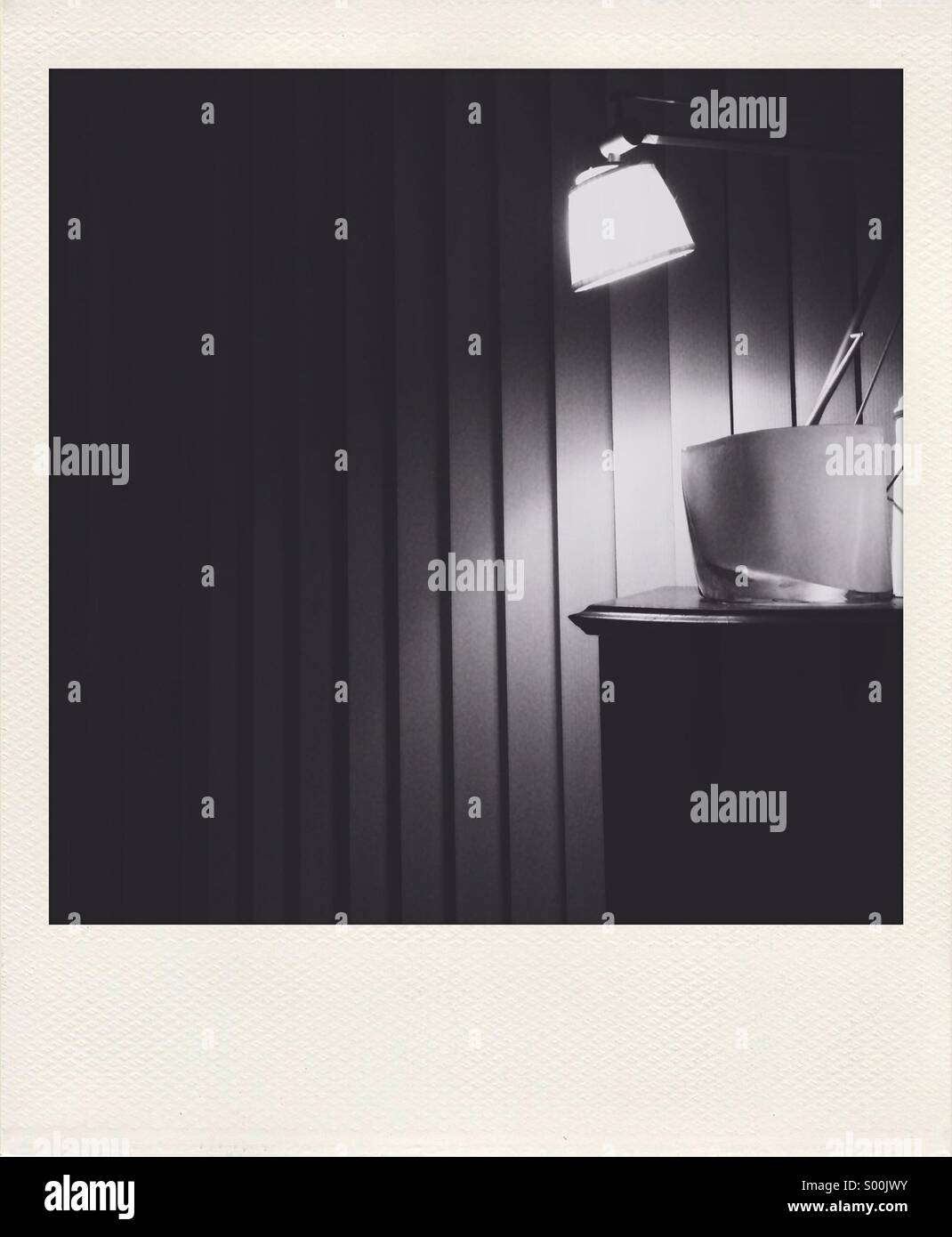 Polaroid-Stil schwarz / weiß-Foto von Philippe Stärke Designerleuchte gegen vertikale Jalousien Stockfoto