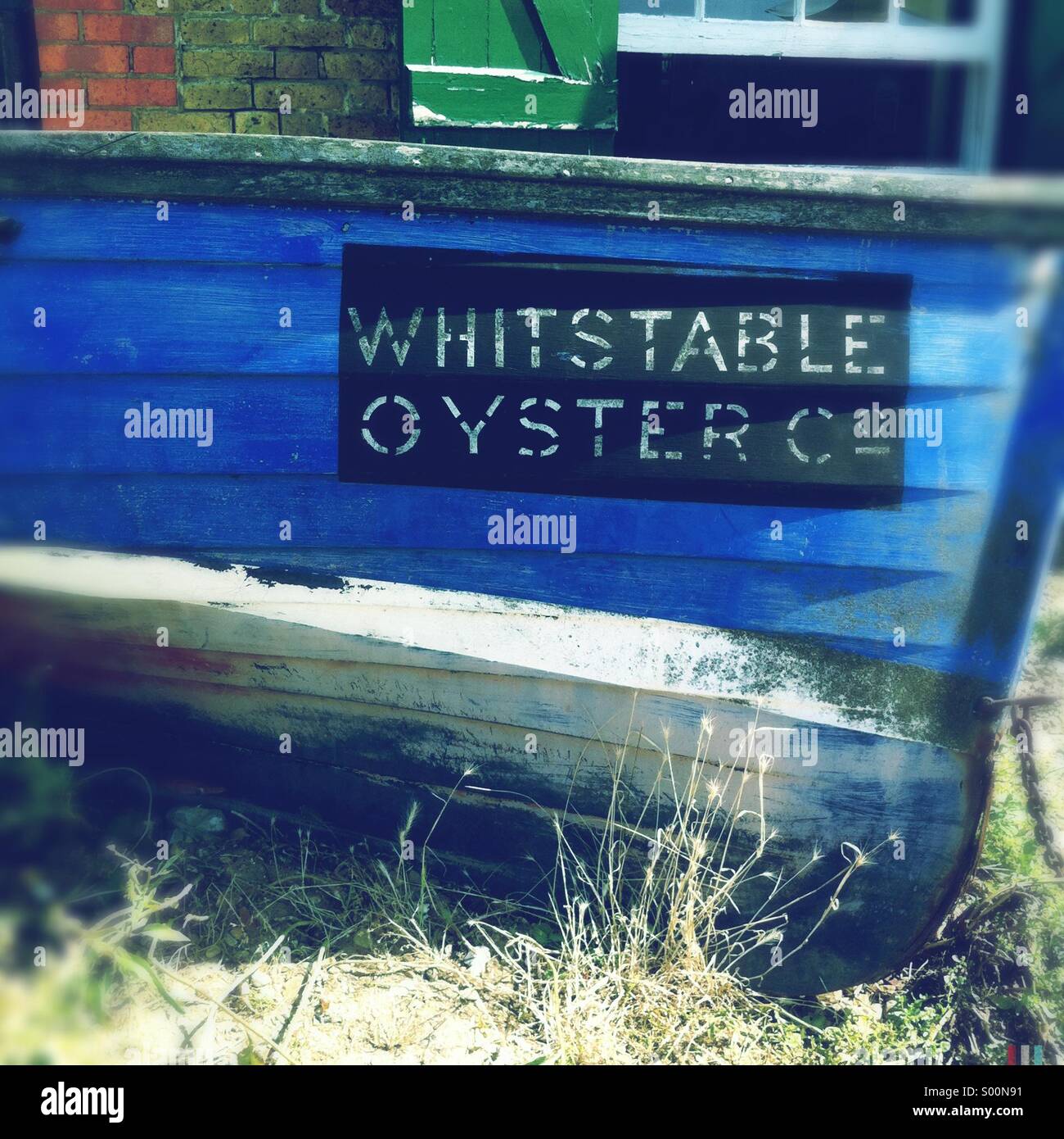 Eine verwitterte Ruderboot zeigt den Namen des Whitstable Oyster Company in Whitstable, Kent, UK. Stockfoto
