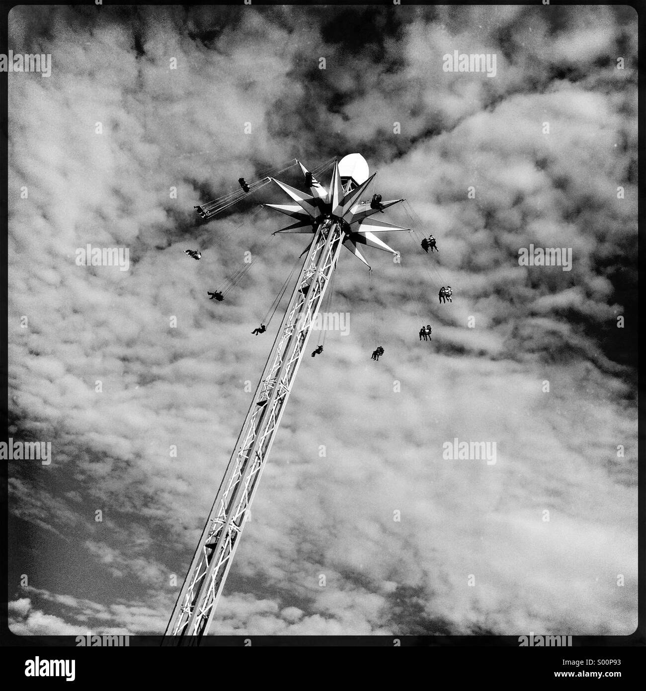 Schwarz / weiß Foto von Menschen reiten einen Star Flyer Festplatz fahren hoch in die Luft. Stockfoto