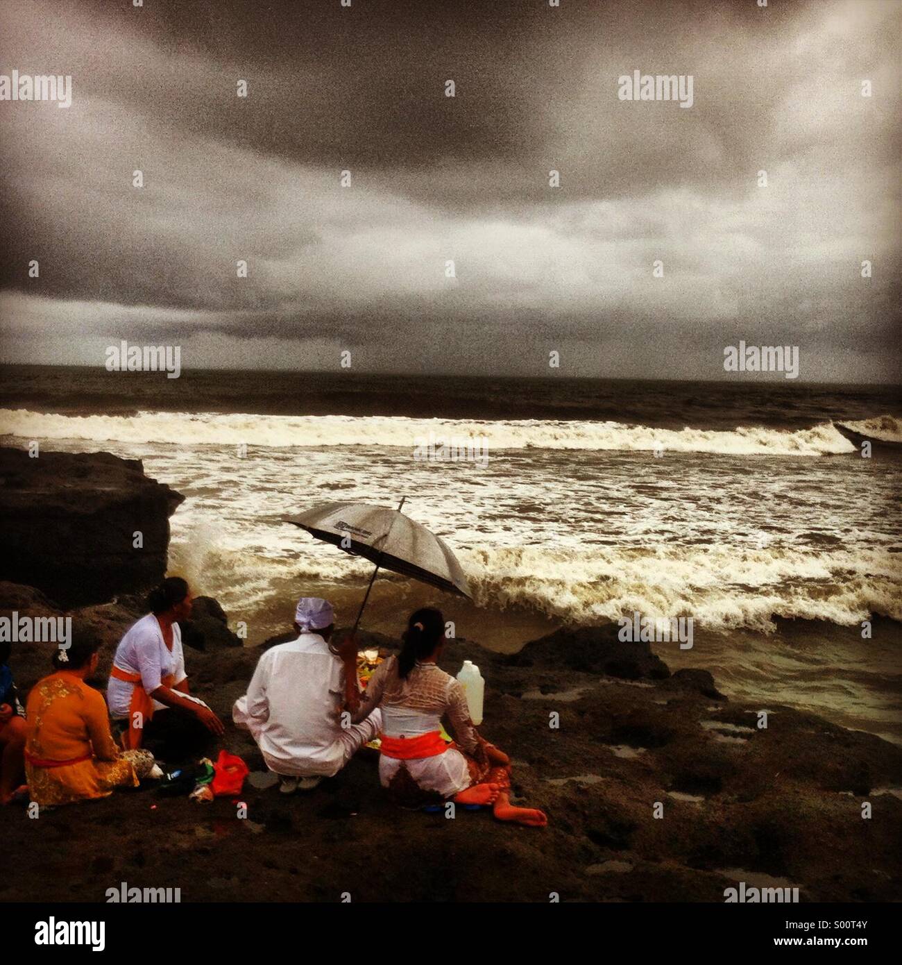 Familie Erlass von religiösen Riten auf dem Seeweg in Bali Stockfoto