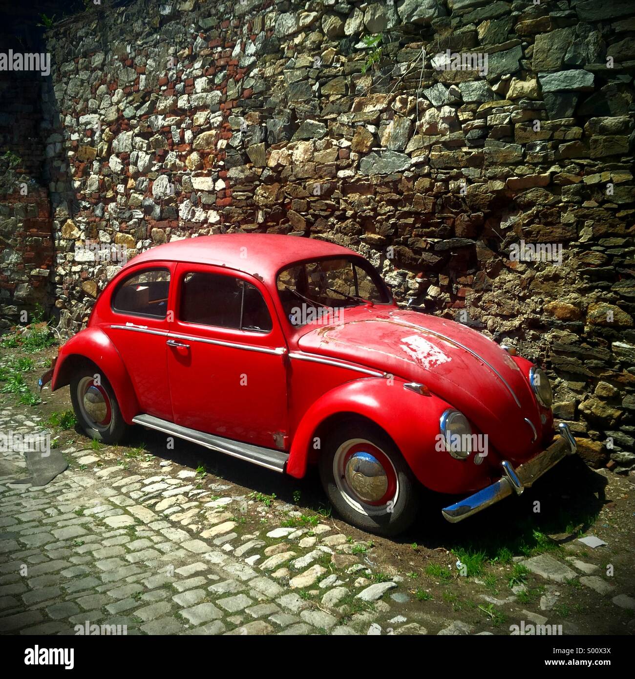 Alten roten VW Käfer (Bug) in einer Seitenstraße von Cesky Krumlov in Tschechien. Stockfoto