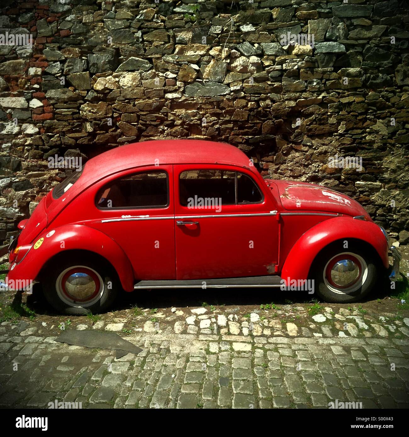 Rote Vintage VW Käfer (Bug) in einer Seitenstraße von Cesky Krumlov in Tschechien. Stockfoto