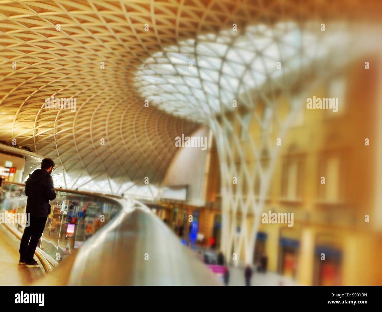 Warten auf einen Zug auf die neue Bahnhofshalle an der Kings Cross Station London. - Smartphone-aufgenommenes Stockfoto
