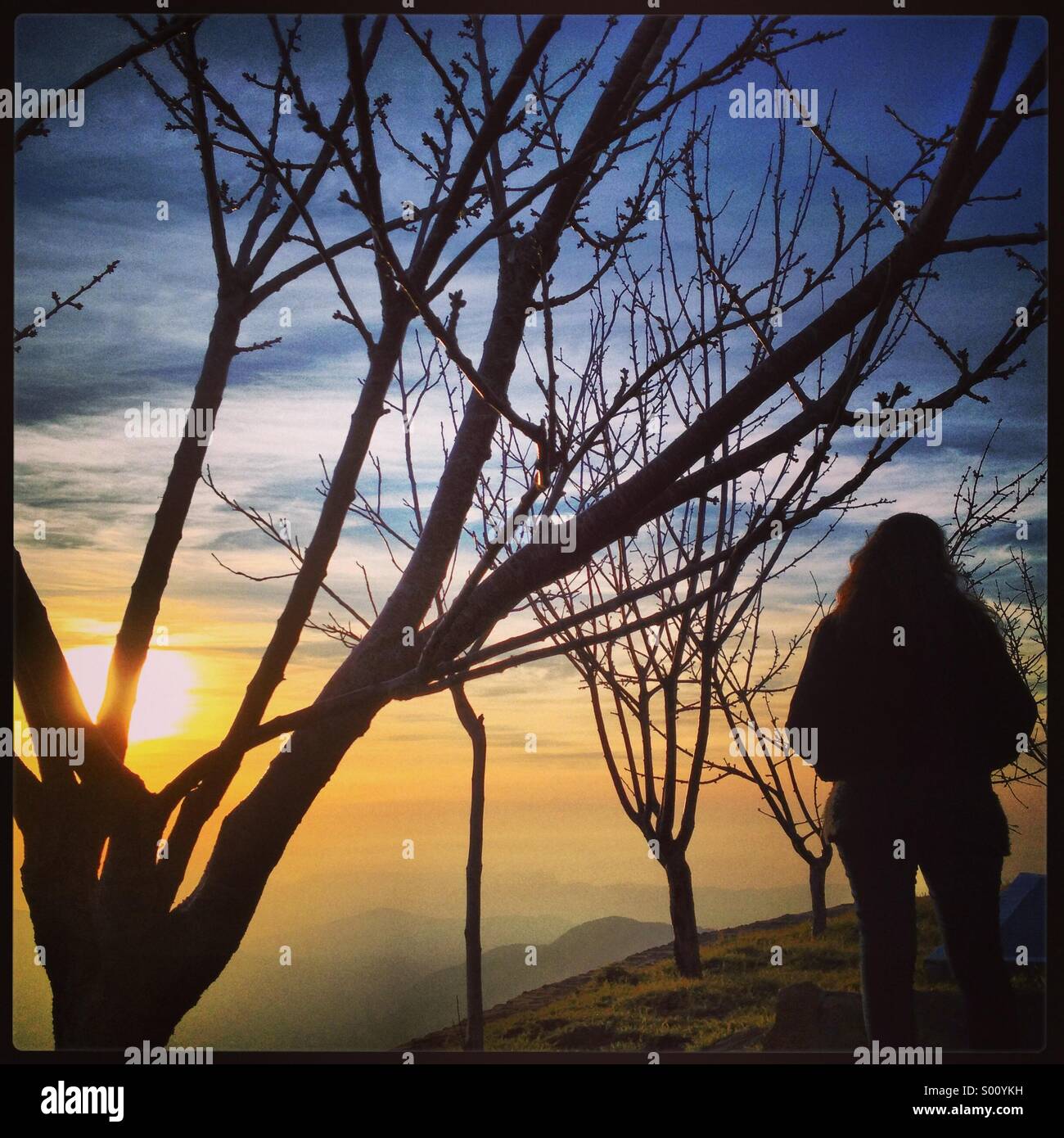 Dame, die den Sonnenuntergang hinter den Bergen in Ehden - Libanon-Nahost - Smartphone-aufgenommenes Stockfoto