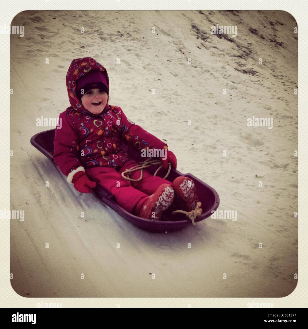 Mädchen-Schlitten fahren im Winter. Stockfoto