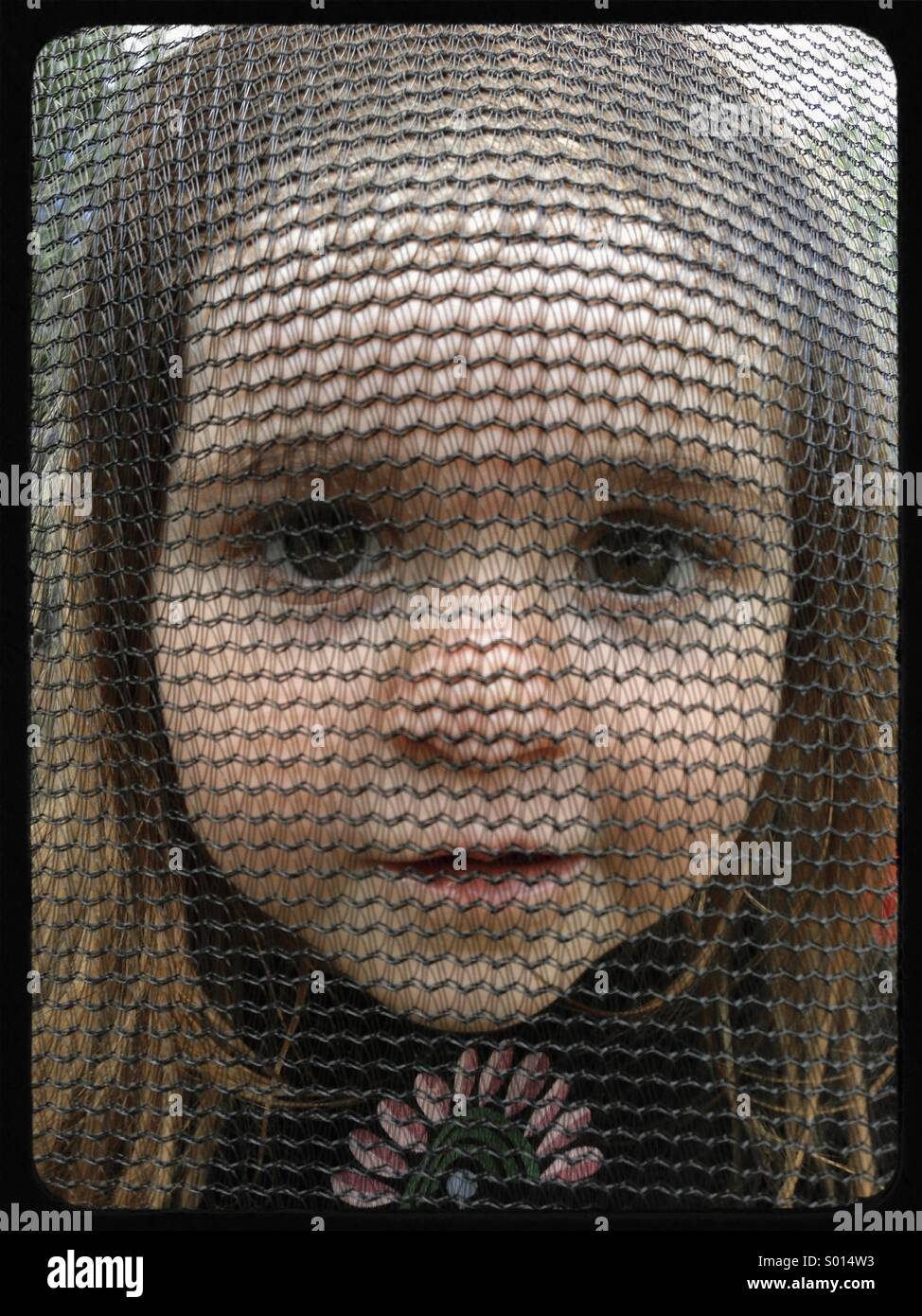 Junges Mädchen mit Fave gegen Netz auf Trampolin Stockfoto