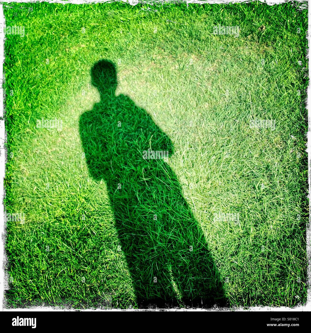 Schatten der Person auf dem Rasen. Selfie, London, UK. Hipstamatic, iPhone. Stockfoto