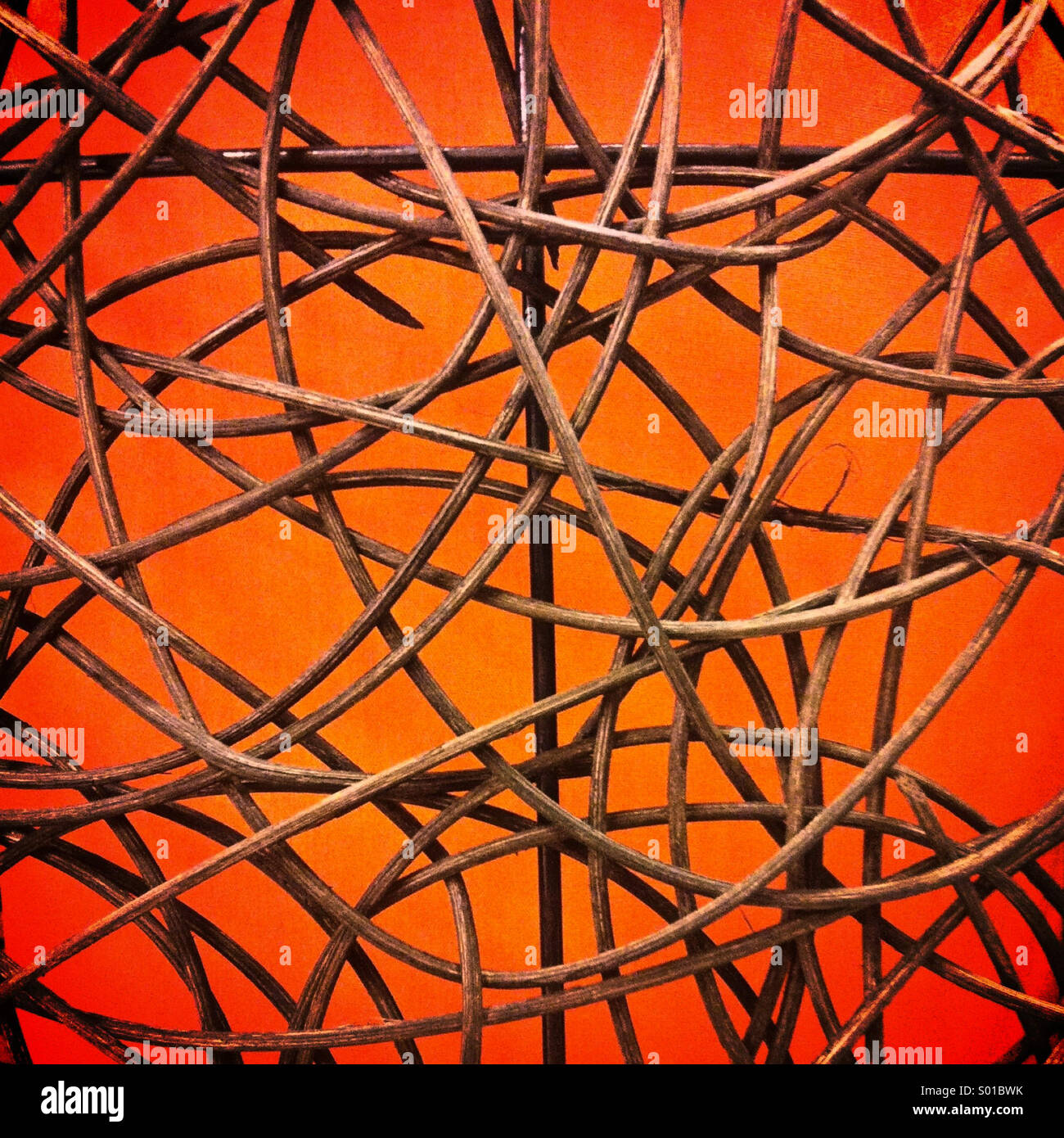 Ein abstraktes Muster der gebogenen Holzstäbchen beleuchteten orange leuchtenden Hintergrund Stockfoto