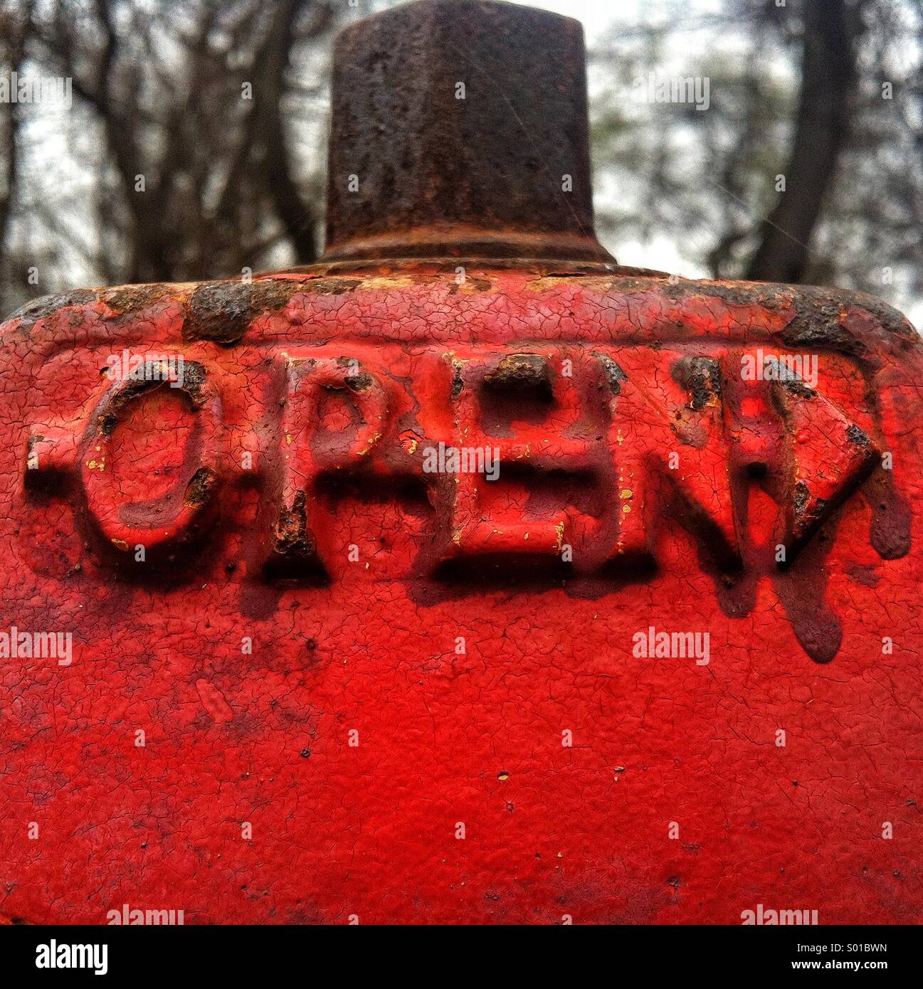 Das Wort "open" auf einem rostigen roten Hydranten - Smartphone-aufgenommenes Stockfoto