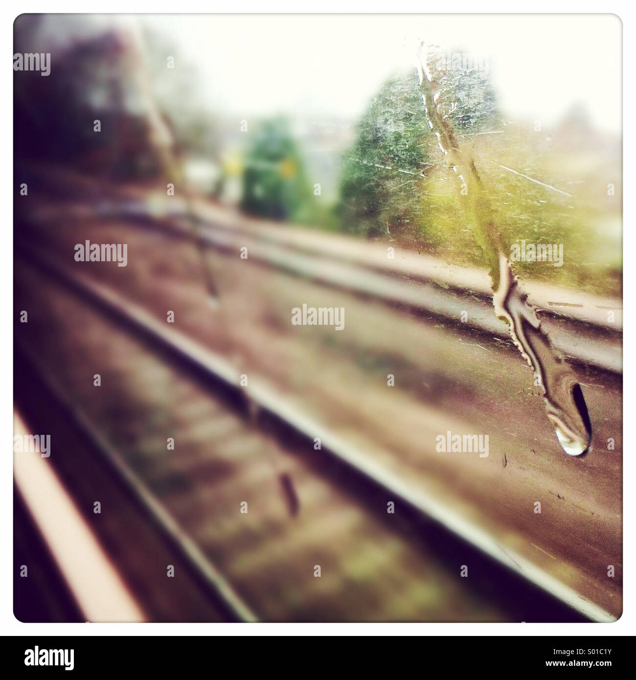Tropfen Wasser an einem Zugfenster mit Spuren sichtbar hinter - Smartphone-aufgenommenes Stockfoto