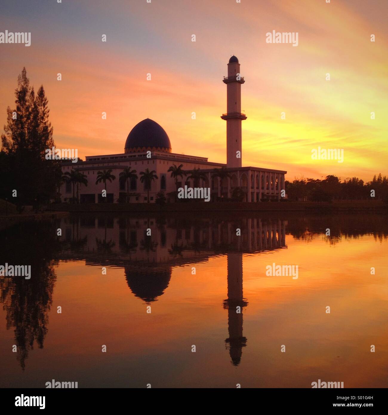 Sonnenaufgang am See in der Nähe einer Moschee Stockfoto