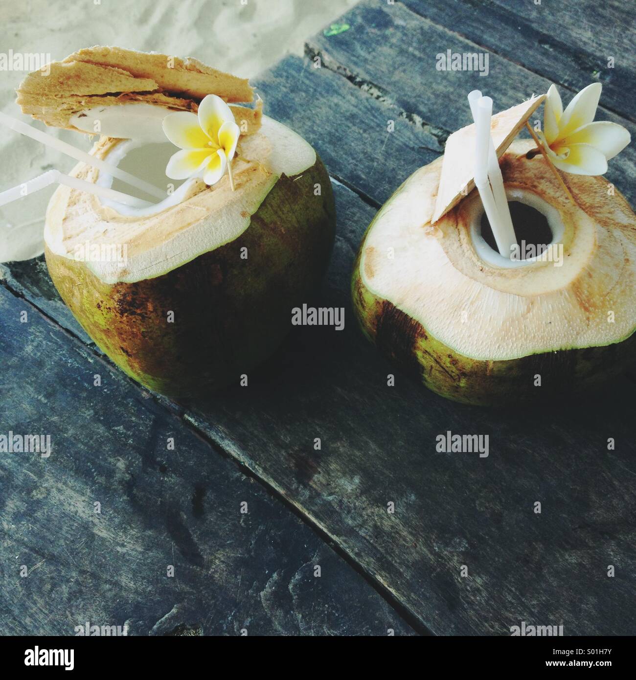 Zwei frische junge Kokosnuss Wasser Getränke mit einem Strohhalm am Strand. Stockfoto