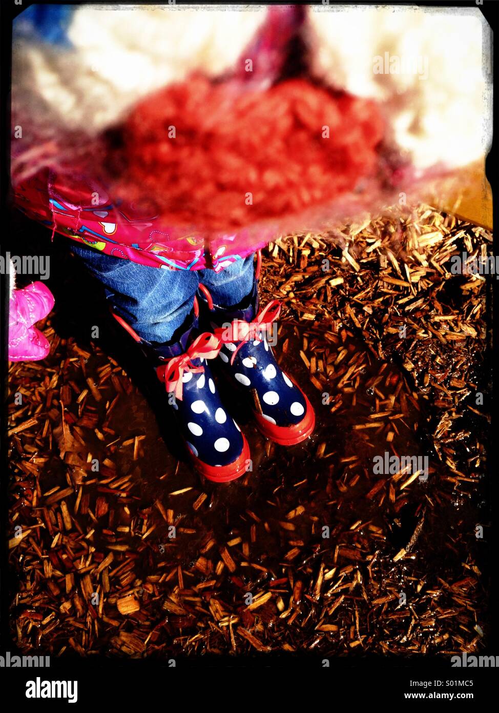 Kleines Mädchen in gepunkteten Gummistiefel. Stockfoto