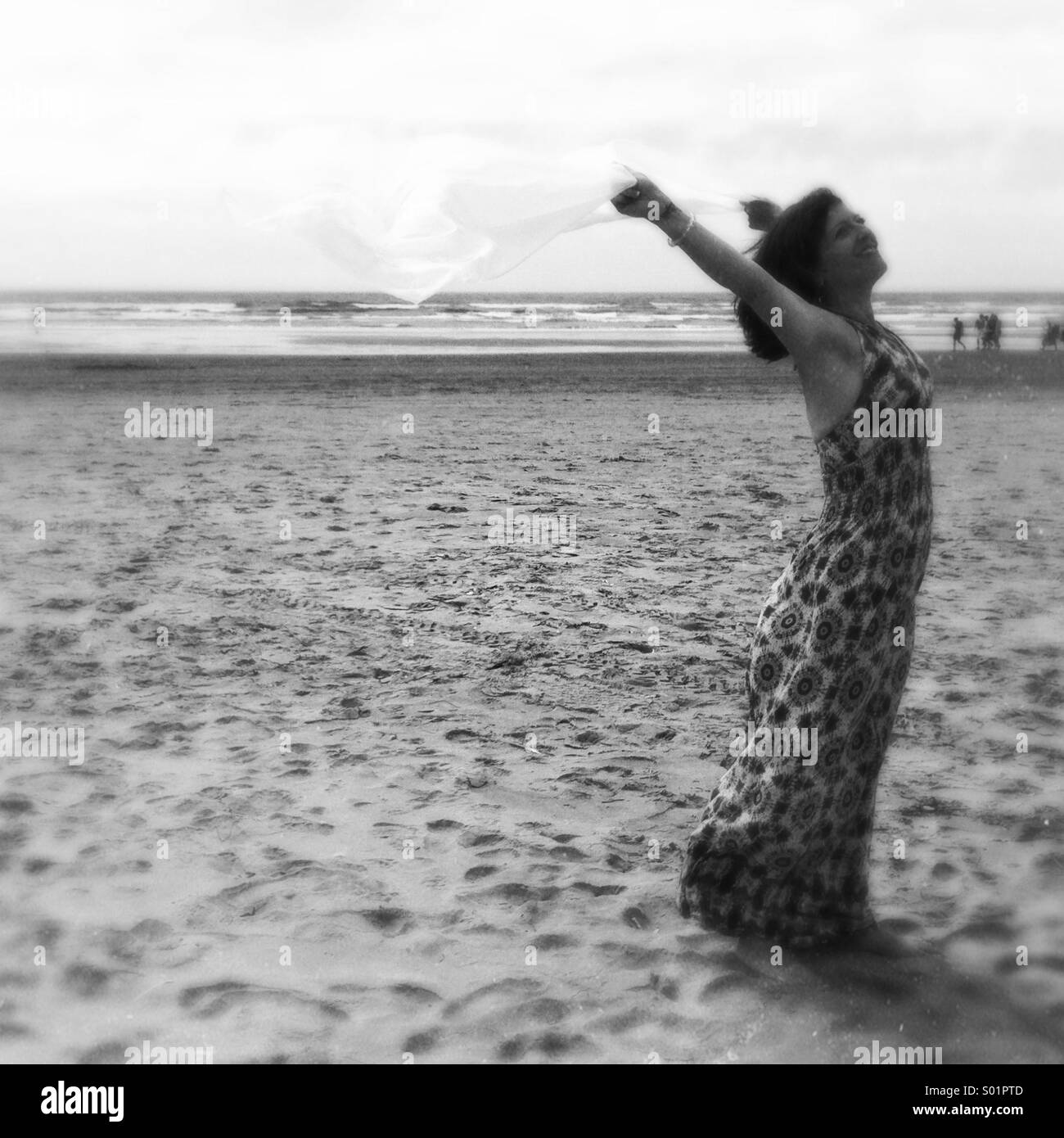 Frau mit Schal im Wind am Strand Stockfoto