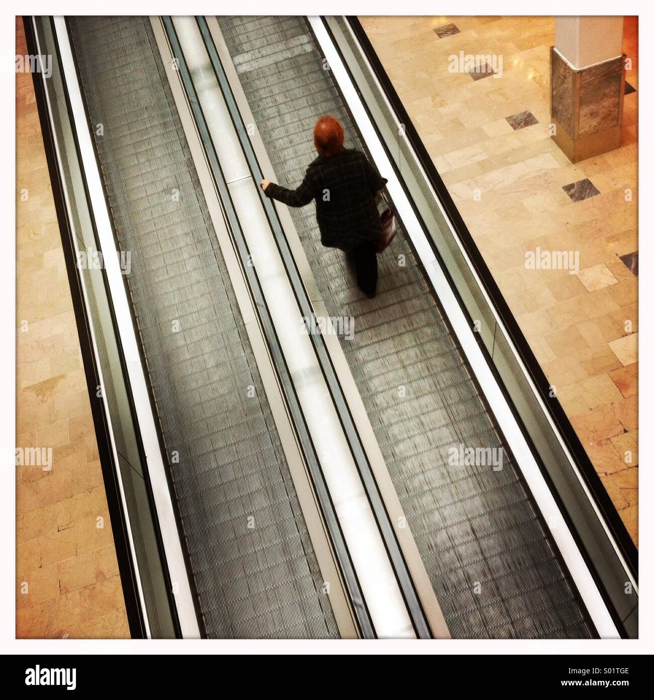 Frau auf der Rolltreppe Stockfoto