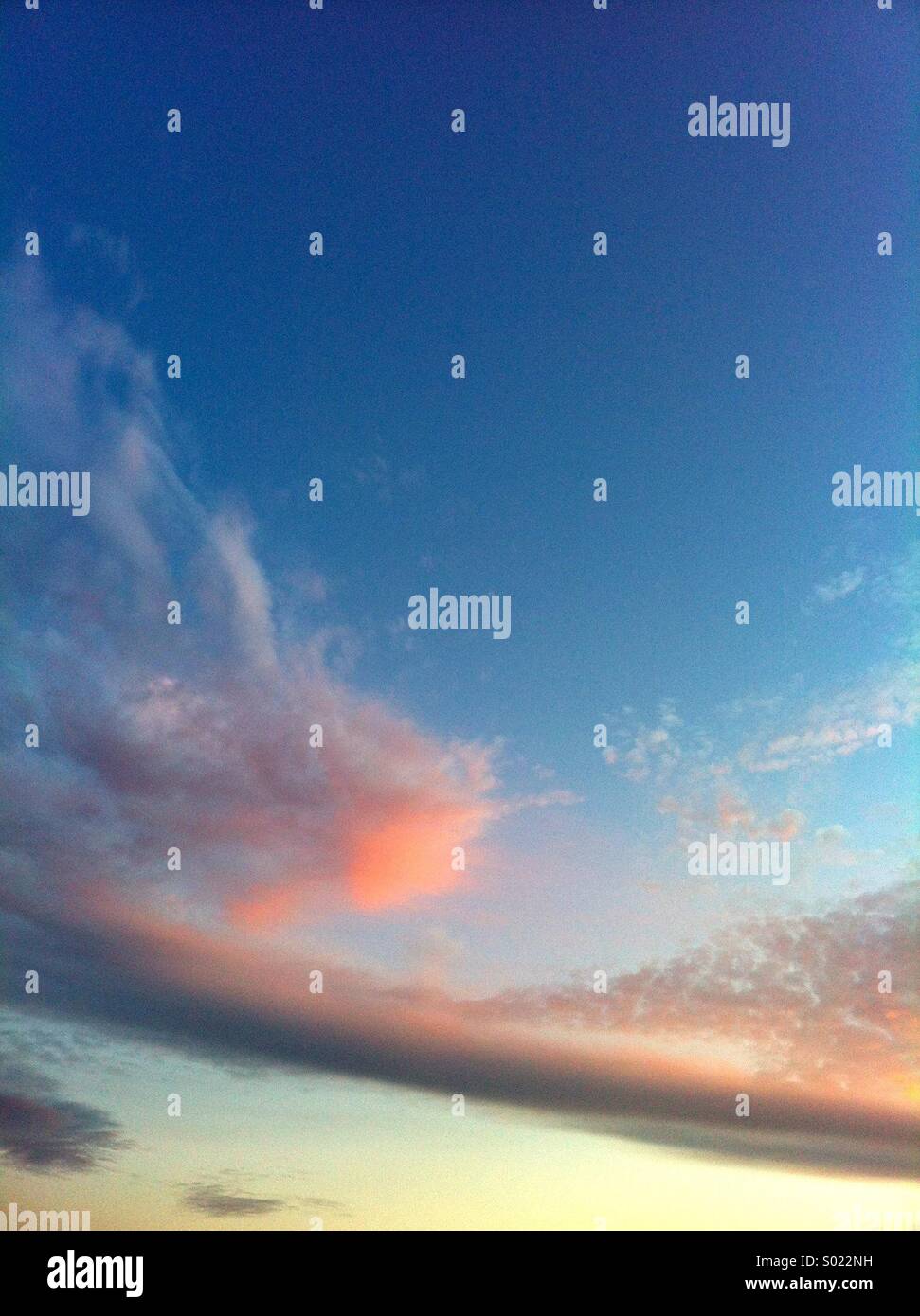 Rosa Wolke am blauen Himmel bei Sonnenuntergang Stockfoto