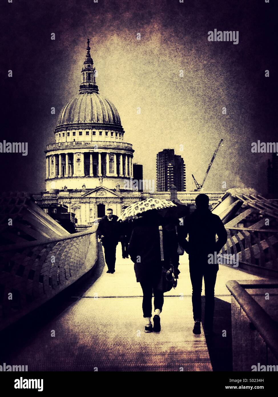 Menschen mit Regenschirmen überqueren die Millennium Bridge in Richtung St. Pauls Cathedral in London, England, UK. - Smartphone-aufgenommenes Stockfoto