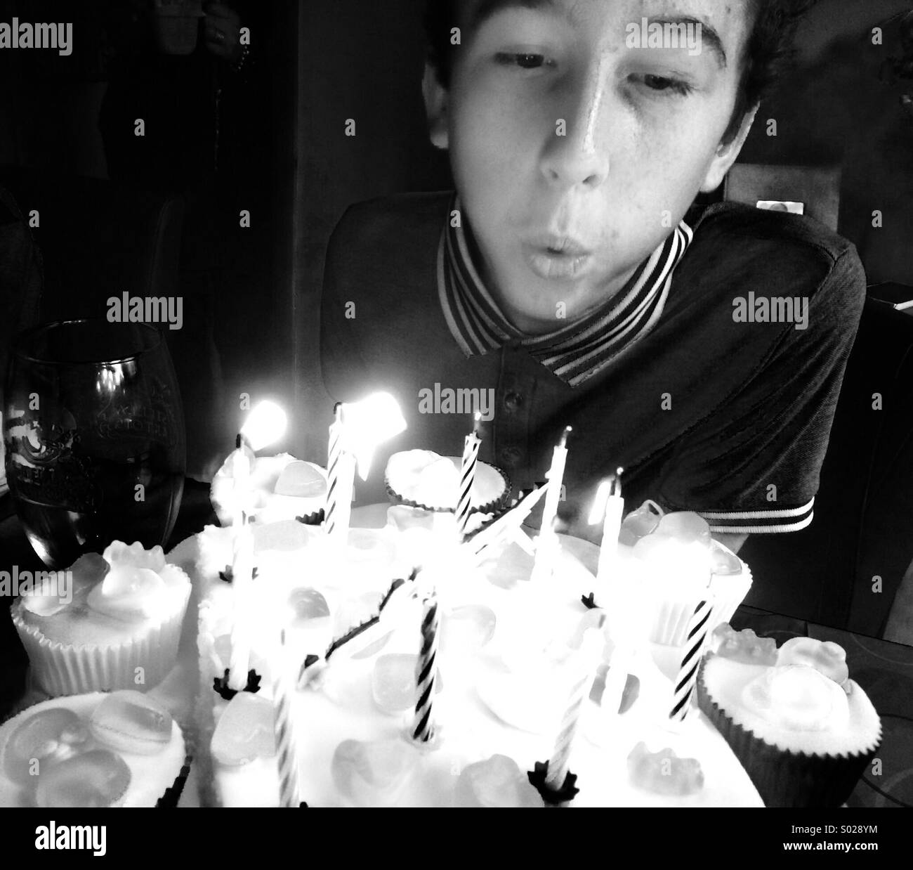 Young Boy Kerzen auf der Geburtstagstorte ausblasen. Stockfoto