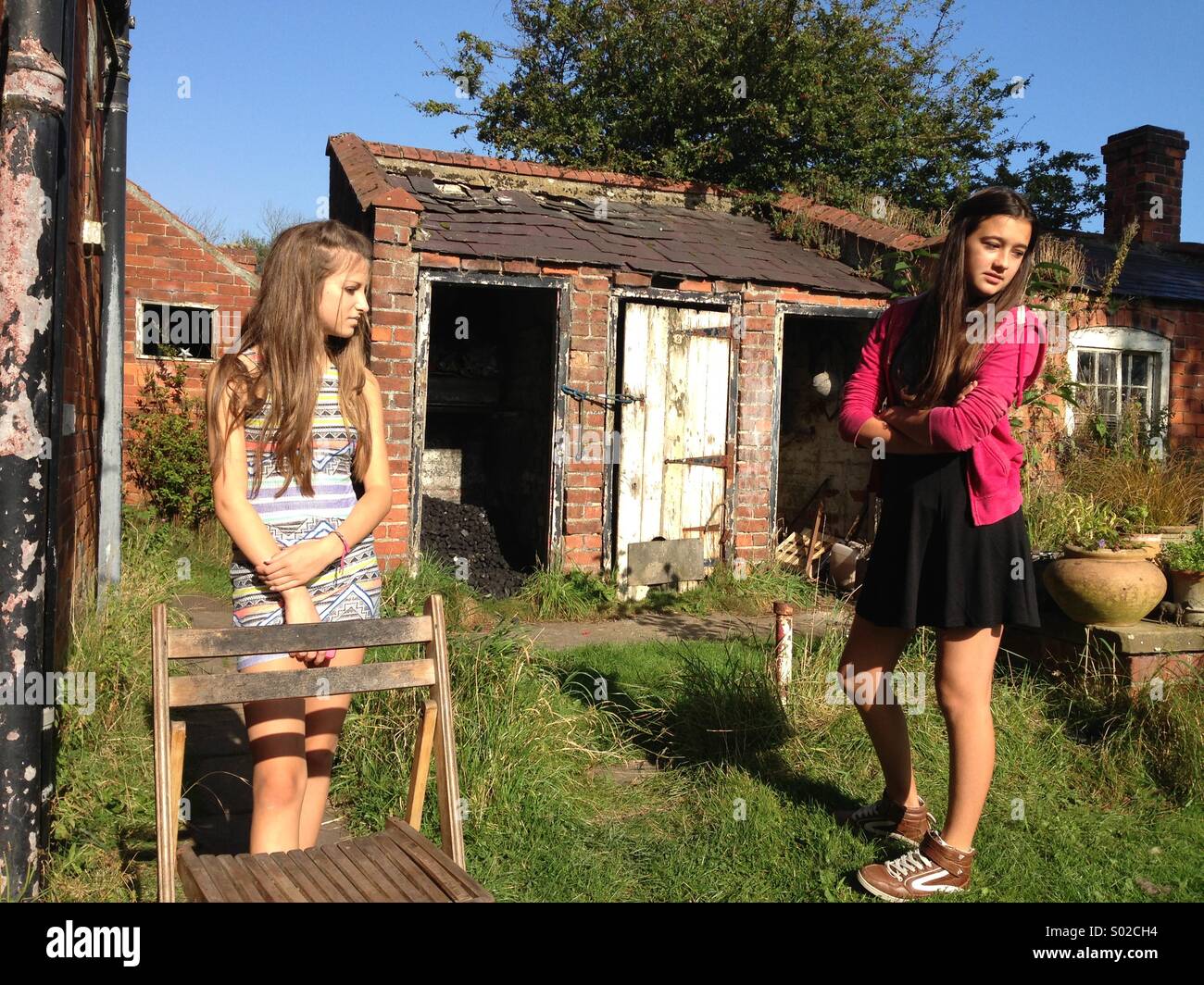 Zwei sulky Teenager-Mädchen in einem Garten Stockfoto