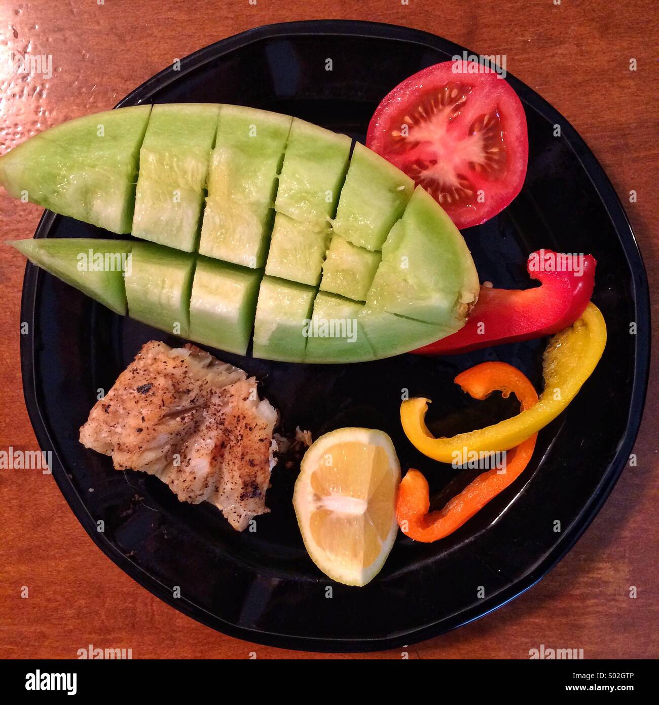 Gesunde kalorienarme Mahlzeit Fisch, Paprika, Tomate und Melone. Stockfoto