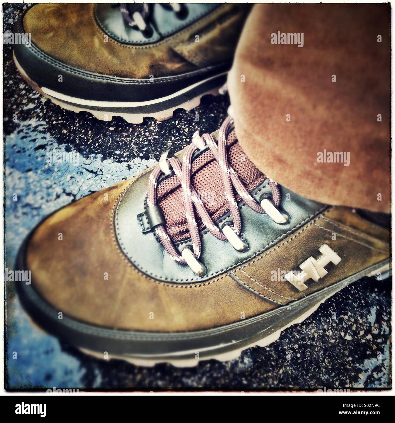 Schuhe auf nassem asphalt - Smartphone-aufgenommenes Stockfoto